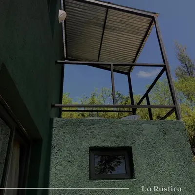 a window on the side of a green building at La Rústica in La Bolsa
