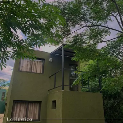 a green building with trees in front of it at La Rústica in La Bolsa