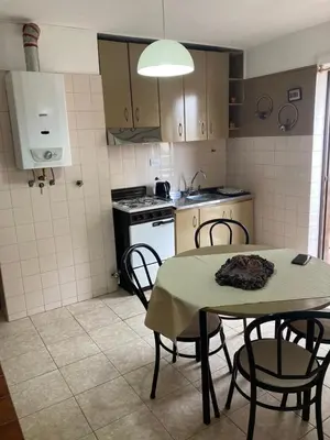 a kitchen with a table and chairs and a stove at Pacífico Il in Cordoba