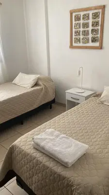 a bedroom with two beds and a table with a lamp at Pacífico Il in Cordoba