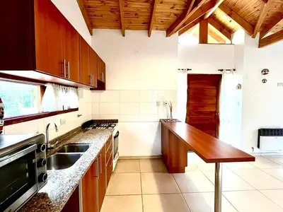 a kitchen with a sink and a wooden counter top at La Casita de Karen in Villa General Belgrano
