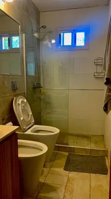 a bathroom with a toilet and a glass shower at La Casita de Karen in Villa General Belgrano