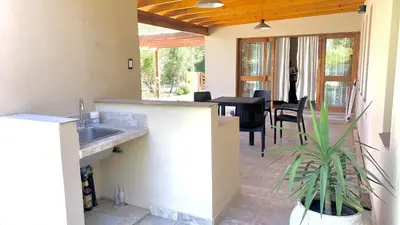a kitchen and dining room with a table and a plant at La Casita de Karen in Villa General Belgrano