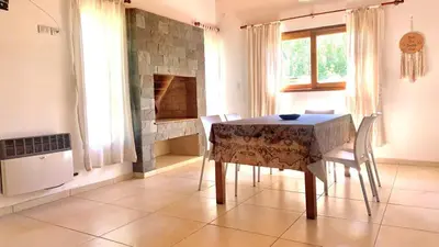 a dining room with a table and chairs and a fireplace at La Casita de Karen in Villa General Belgrano