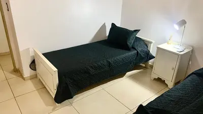 a bedroom with a bed with a black comforter at La Casita de Karen in Villa General Belgrano