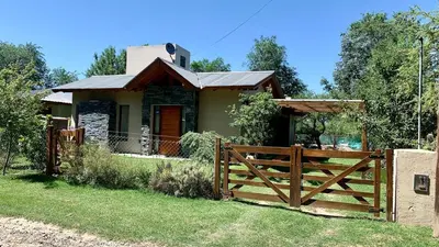 a house with a wooden fence in front of it at La Casita de Karen in Villa General Belgrano