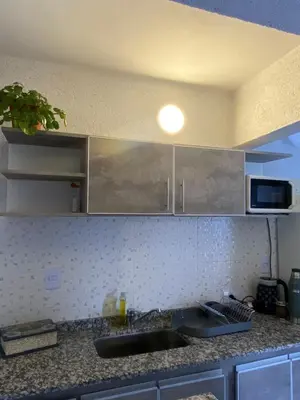 a kitchen counter with a sink and a microwave at Departamento 2 dormitorios Villa Carlos Paz in Villa Carlos Paz
