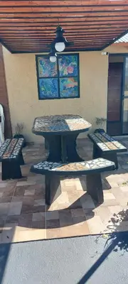 a picnic table and benches on a patio at Departamento 2 dormitorios Villa Carlos Paz in Villa Carlos Paz
