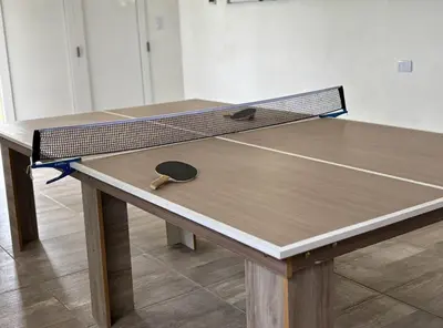 a ping pong table with a ping paddle on it at Cabaña con spa Vida Abundante in Villa Yacanto