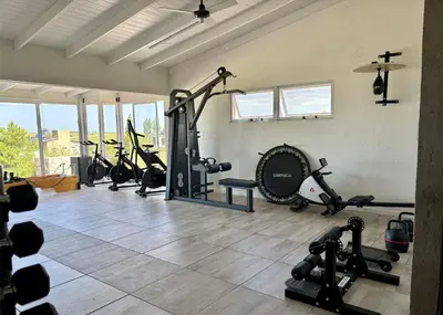 a gym with a bunch of exercise equipment in a room at Cabaña con spa Vida Abundante in Villa Yacanto