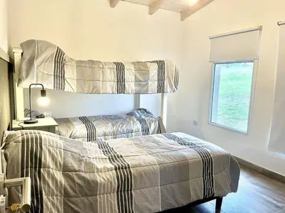 a bedroom with two beds and a window at Cabaña con spa Vida Abundante in Villa Yacanto