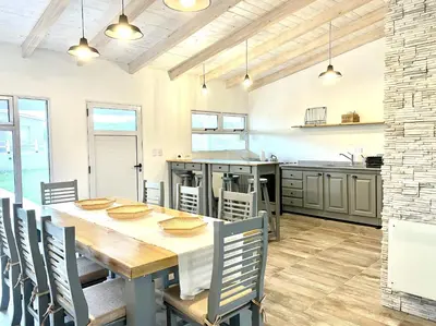 a large kitchen with a wooden table and chairs at Cabaña con spa Vida Abundante in Villa Yacanto