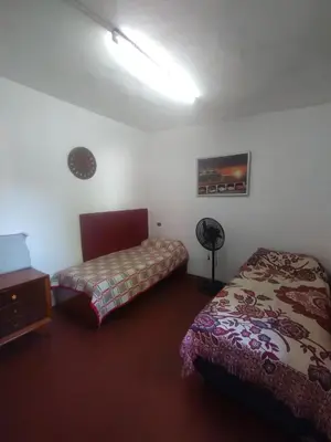 a bedroom with two beds and a lamp in it at Depto Cura Gaucho in Mina Clavero