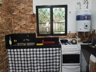 a kitchen with a white stove and a sink at Depto Cura Gaucho in Mina Clavero