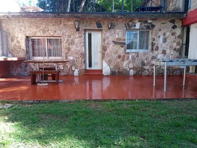 a patio with a table in front of a stone building at Depto Cura Gaucho in Mina Clavero