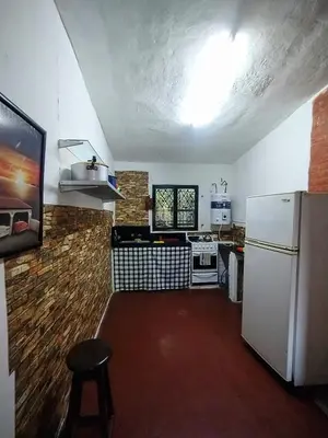 a kitchen with a white refrigerator and a stove at Depto Cura Gaucho in Mina Clavero