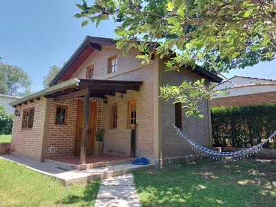 a house with a hammock in front of it at La Cabañita in Villa General Belgrano