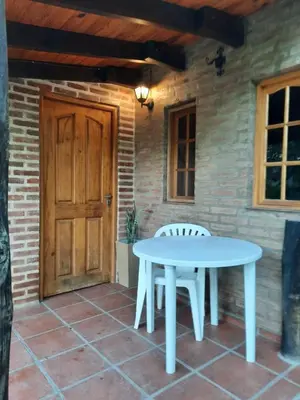 a table and chairs on a patio with a door at La Cabañita in Villa General Belgrano