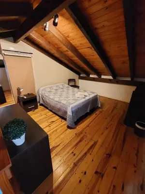a bedroom with a bed and a wooden floor at La Cabañita in Villa General Belgrano