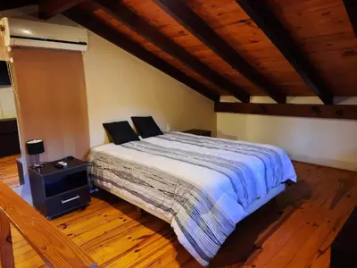 a bedroom with a bed and a wooden floor at La Cabañita in Villa General Belgrano