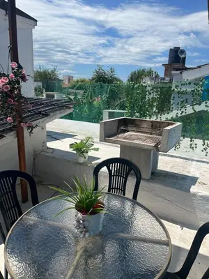 a patio with a table and chairs and a fire pit at Dpto Santa Rosa in Santa Rosa de Calamuchita