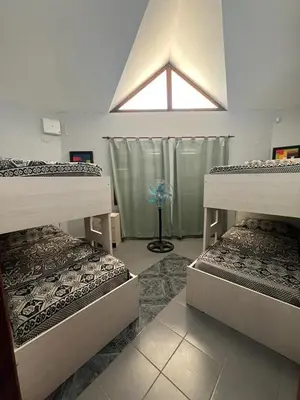 a room with three bunk beds and a window at Dpto Santa Rosa in Santa Rosa de Calamuchita