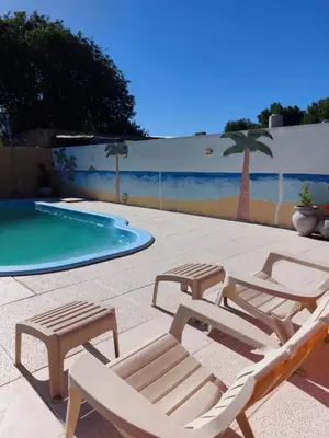 a group of lounge chairs and a swimming pool at Cabañas Los Materos in Santa María
