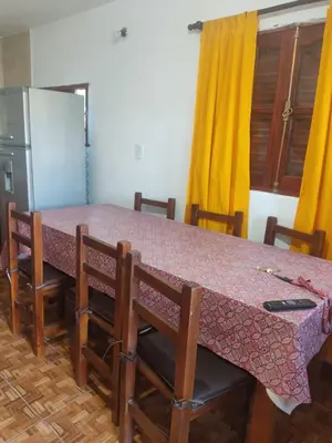 a kitchen with a table with chairs and a refrigerator at Cabañas Los Materos in Santa María