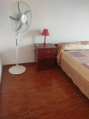 a bedroom with a fan next to a bed and a nightstand at Cabañas Los Materos in Santa María