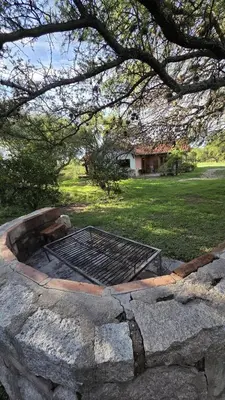 a fire pit in the middle of a stone wall at Atardecida in Villa de Las Rosas