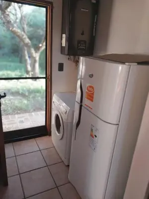 a kitchen with a refrigerator and a washing machine at Atardecida in Villa de Las Rosas