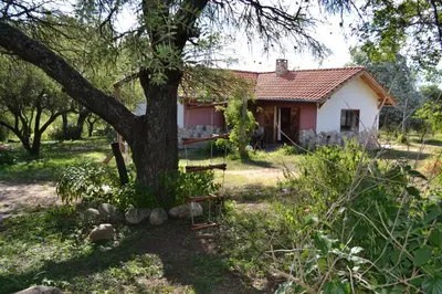 a small house with a tree in front of it at Atardecida in Villa de Las Rosas
