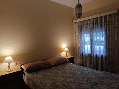 a bedroom with a bed with two lamps and a window at Casa en Carlos Paz in Villa Carlos Paz