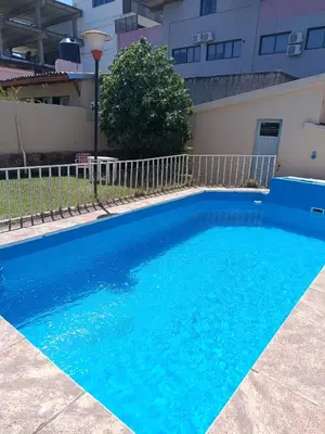 a swimming pool with blue water in front of a building at Casa en Carlos Paz in Villa Carlos Paz