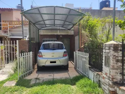 a white car parked in a garage with a fence at Casa en Carlos Paz in Villa Carlos Paz