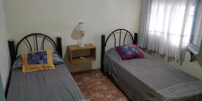 two beds sitting in a room with a window at Casa en Carlos Paz in Villa Carlos Paz