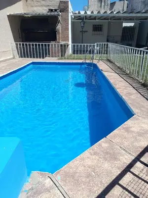 a blue swimming pool in front of a house at Casa en Carlos Paz in Villa Carlos Paz