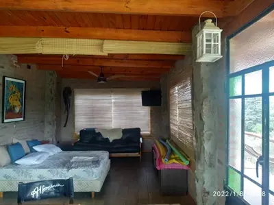 a bedroom with two beds and a couch in a room at Cabaña LA PEDRERA - Pileta y a metros del Rio in Bialet Massé