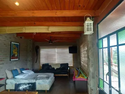 a bedroom with a bed and a couch in a room at Cabaña LA PEDRERA - Pileta y a metros del Rio in Bialet Massé