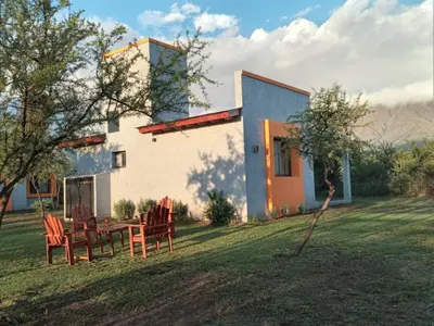 a house with a table and chairs in the yard at Complejo La Dorada in Merlo
