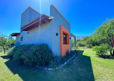 a small house with an orange door on a yard at Complejo La Dorada in Merlo