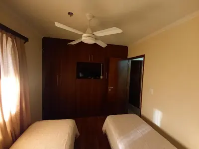 a bedroom with two beds and a ceiling fan at MIRALEJOS 6 CENTRO in Villa Carlos Paz