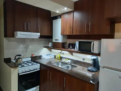 a small kitchen with a sink and a microwave at MIRALEJOS 6 CENTRO in Villa Carlos Paz