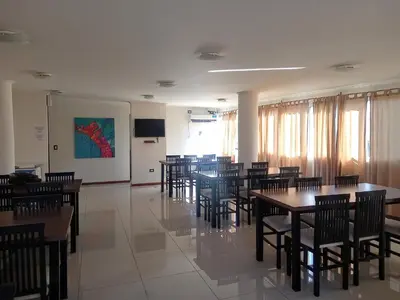 a dining room with tables and chairs and a screen at MIRALEJOS 6 CENTRO in Villa Carlos Paz