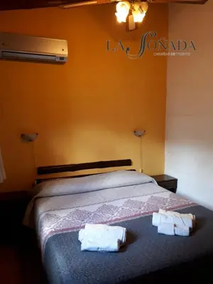 a bedroom with a bed with two towels on it at La Soñada Cabañas & Spa in Merlo