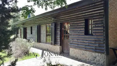 a wooden house with a door on the side of it at La Soñada Cabañas & Spa in Merlo
