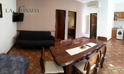 a living room with a wooden table and a couch at La Soñada Cabañas & Spa in Merlo