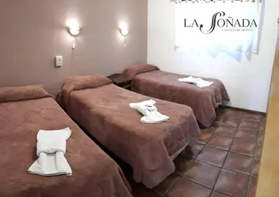 a room with three beds with white shoes on them at La Soñada Cabañas & Spa in Merlo