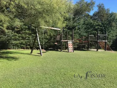 a playground with two swings in a grass field at La Soñada Cabañas & Spa in Merlo