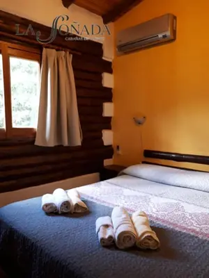 a bedroom with a bed with towels on it at La Soñada Cabañas & Spa in Merlo